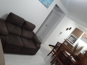 sala de estar con sofá, mesa y sillas en Apto Rústico comfy Garg wifi próx a políc Federal serve 5 hóspedes, en Curitiba
