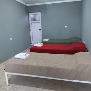 two beds sitting in a room with a mirror at Hostal Lo de Ramona in Belén