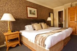 A bed or beds in a room at Stuart House Hotel