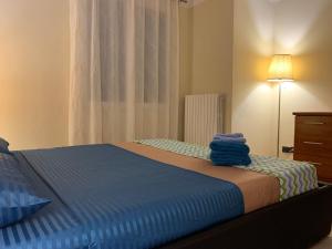 リヴォルノにあるLa Casetta di Ashのベッドルーム1室(青いシーツとランプ付)