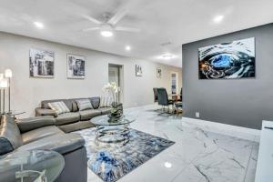 ein Wohnzimmer mit einem Sofa und einem Tisch in der Unterkunft Three Bedroom Pool Home with Modern Interior Design in Coral Springs