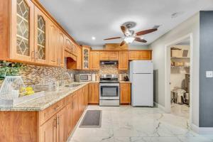 eine Küche mit Holzschränken und einem weißen Kühlschrank in der Unterkunft Three Bedroom Pool Home with Modern Interior Design in Coral Springs