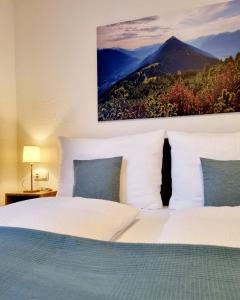 a bedroom with a white bed with a picture on the wall at Appartements Falkner in Roppen