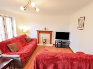 a living room with a red couch and a television at 17 Kings Court in Boston