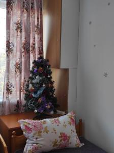 Un árbol de Navidad sentado en una cama junto a una almohada en IGLIKA 2 SNOWY NIGHT V18, en Borovets