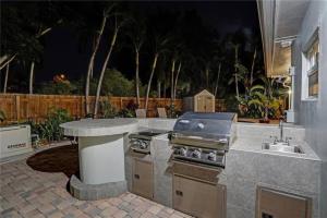 フォート・ローダーデールにあるChic Victoria Park Villa with Heated Pool and Spaの屋外キッチン(グリル、シンク付)