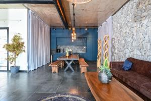 una sala de estar con un sofá y una mesa en הודולה - וילות נדירות עם בריכות מחוממות פרטיות ונוף מושלם לכנרת, en Giv'at Yo'av