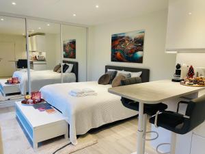 1 dormitorio con cama, escritorio y mesa en Prachtig guesthouse met gratis parkeren, en Maasmechelen