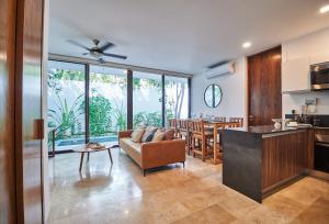 uma cozinha e sala de estar com um sofá e uma mesa em Omara 2-BR Pool · Tropical 2-BR Condo With Private Pool + Amenities! em Tulum