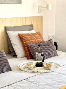 taca z 2 filiżankami i zestaw do parzenia herbaty na łóżku w obiekcie PAOLA Comfort Apartment w mieście Costa Calma