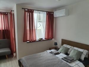 a bedroom with a bed with red curtains and a window at Апартамент B9 in Borovets +35 photos