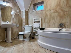 a bathroom with a sink and a toilet and a tub at Pensiunea Mirage in Iaşi +29 photos