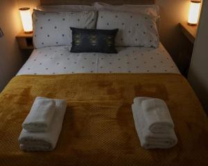 a bedroom with a bed with two towels on it at Bimble Lodge in Langport