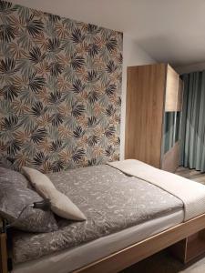 ein Schlafzimmer mit einem Bett mit einer Wand in der Unterkunft Tila in Wałcz
