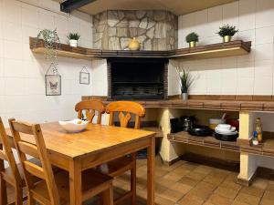 - une cuisine avec une table et des chaises en bois dans l'établissement La Bruixa Rural, à Dosríus