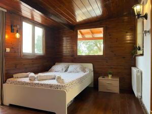 a bedroom with a bed in a room with wooden walls at La Bruixa Rural in Dosríus
