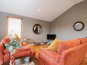 a living room with two couches and a tv at Woodbridge Penthouse in Woodbridge