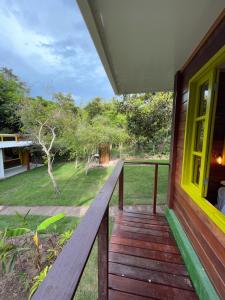 - une terrasse couverte en bois d'une maison avec vue sur la cour dans l'établissement Chalés Mata da Praia Corumbau, à Corumbau
