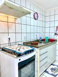 a white kitchen with a stove and a sink at Apto charmoso na V Planalto perto Shopping com 2 Quartos ArCond Wifi Fibra Home Office e Garagem em Dourados in Dourados