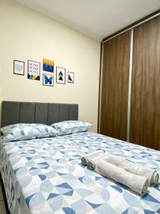1 dormitorio con 1 cama con edredón azul y blanco en Apto charmoso na V Planalto perto Shopping com 2 Quartos ArCond Wifi Fibra Home Office e Garagem em Dourados, en Dourados