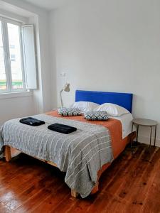 Un dormitorio con una cama grande con cabecero azul. en Casa Vale Apartments, en Lisboa