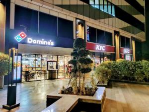 a mall with a tree in front of a building at 2BHK 65TV,FullyAC,family,Unmarried Couple,WFO Friendly peacefull place in Noida