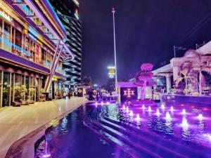 a city street at night with a fountain and buildings at 2BHK 65TV,FullyAC,family,Unmarried Couple,WFO Friendly peacefull place in Noida
