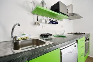 een keuken met groene kasten en een wastafel bij Villa Kata in Sičane
