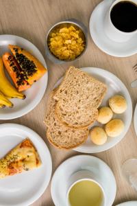a table with plates of food and a cup of coffee at Ok Inn Hotel Floripa in Florianópolis +57 photos