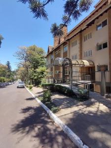 a building with a car parked next to a street at Charmoso, Junto ao Mini Mundo, para sair e deixar o carro na Garagem. in Gramado