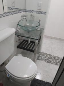 y baño con aseo y lavamanos de cristal. en Acogedor Apartamento en Centro de Buenos Aires Cerca del Obelisco en Buenos Aires