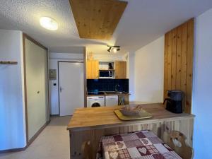 a kitchen with a wooden island in a room at Appartement confortable à Val Cenis Lanslebourg, 300m des pistes, 5 personnes, balcon, casier à skis - FR-1-508-40 in Lanslebourg-Mont-Cenis