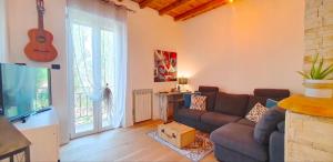 a living room with a couch and a guitar on the wall at Casa Valle Parco Lambro in Albiate