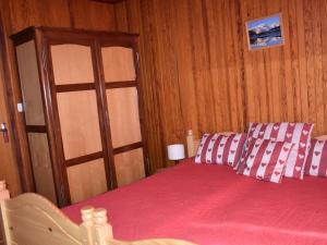 a bedroom with a bed with pink sheets and a door at Appartement Pralognan-la-Vanoise, 3 pièces, 3 personnes - FR-1-464-183 in Pralognan-la-Vanoise