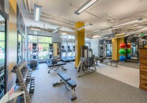 a gym with several treadmills and exercise machines at Fantastic 2BR Condo With Rooftop in Arlington