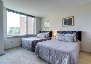 a bedroom with two beds and a large window at Fantastic 2BR Condo With Rooftop in Arlington
