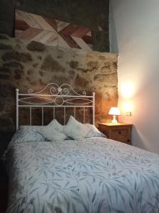 a bedroom with a bed with a metal head board at Casa Rural El Turuterro in Cepeda