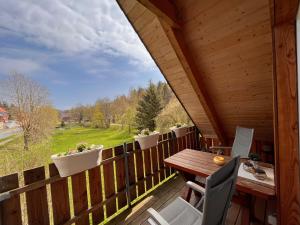 eine Holzterrasse mit einem Tisch und Stühlen darauf in der Unterkunft Hexenstuben Tanne - 4 DTV Sterne in Tanne