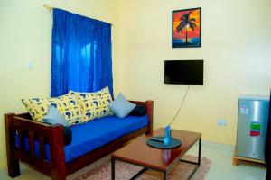uma sala de estar com um sofá azul e uma mesa em Magnolia Cosy 1 Bedroom Apartment-KILIFI em Kilifi