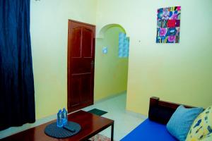 a living room with a table and a red door at Magnolia Cosy 1 Bedroom Apartment-KILIFI in Kilifi