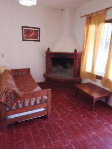 uma sala de estar com 2 camas e uma lareira em CABAÑAS LA PILARICA em San Rafael