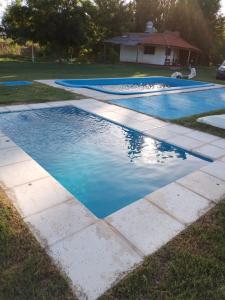 a group of three swimming pools with blue water at CABAÑAS LA PILARICA in San Rafael