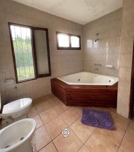 a bathroom with a tub and a toilet and a sink at CABAÑAS LA PILARICA in San Rafael