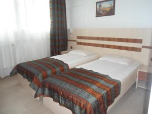 Hotel Turist في Pucioasa: سريرين في غرفة فندق مع
