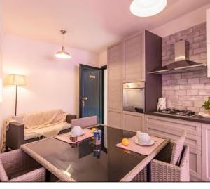 ヴァッレドーリアにあるResidence valledoria2のテーブルと椅子のあるキッチンとリビングルーム