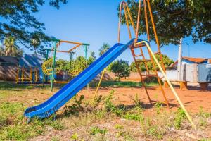 a blue slide in a playground at Casa com 2 suítes, cozinha completa , área de lazer, piscina infantil, 10 min do parque aquático in Andradina