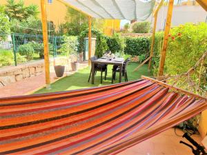 eine Hängematte inmitten einer Terrasse mit einem Tisch in der Unterkunft Apartamento con hermoso jardín y AC in Isla Plana