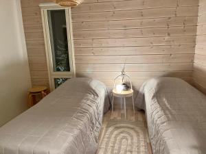 1 dormitorio con 2 camas y mesa auxiliar en Villa Laidike with sauna/fireplace, 80 km Helsinki, en Suomusjärvi