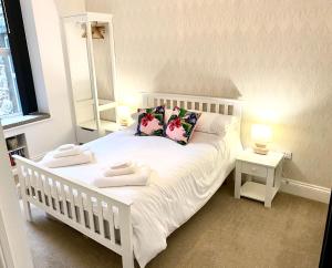 a bedroom with a white bed with two towels on it at Bellaview Apartment Barmouth in Barmouth