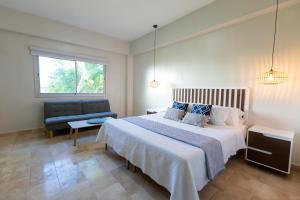 - une chambre avec un grand lit et une chaise dans l'établissement Cap Cana 3br Full Kitchen, Wifi, Smart Check-in, à Punta Cana